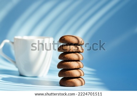 Cup of hot coffee and sweet cookies on blue background. Top view, copy space, mockup. Flat lay. Food and drink.