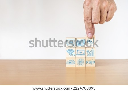 Businessman hand with wood cube block and icon symbol to 5G network high speed mobile internet new age network, mixed media, World wide business