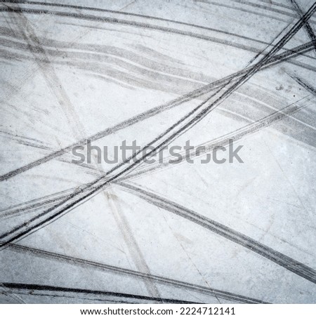 Textured background of vehicle traces on road from scooter, bike, bicycle weel. Tire print texture of transport Royalty-Free Stock Photo #2224712141