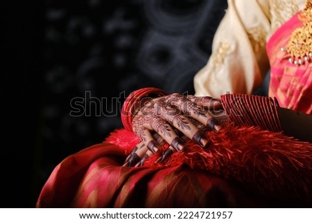 Indian Wedding Bride Showing Henna Designs and jewelry wearing red saree