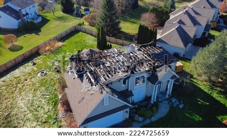 Aerial view upscale residential neighborhood with burnt house between other two story homes in Rochester, New York. Property totally damaged by fire disaster, insurance claim background Royalty-Free Stock Photo #2224725659