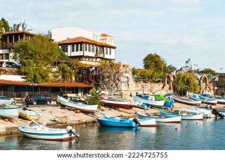 Motor boats parked in the port of Nessebar, Bulgaria. Beautiful panorama of the old city. Fishing boats and yachts on the pier in the bay. Beautiful postcard with a European picture