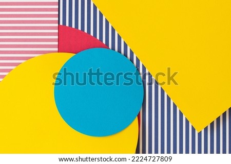 Abstract trendy fashion colored papers texture background in memphis geometry style. Yellow, red, blue, white colors. Geometric shapes and striped lines. Top view, flat lay