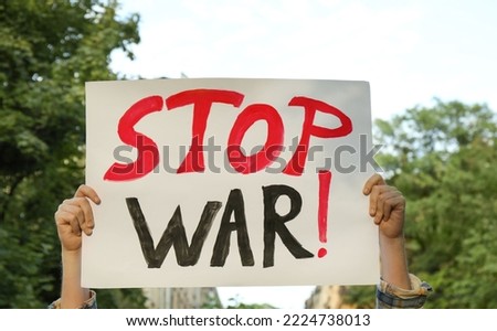 Woman holding poster with words Stop War outdoors, closeup