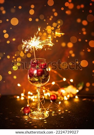 Happy New Year. Burning bengal firework in wine glass