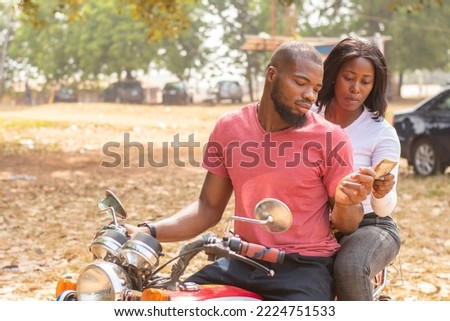african lady on a bike gives the rider money