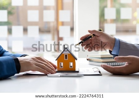 Real estate agent is discussing and explaining the terms of the home purchase contract. Businessman signing a contract agreement, mortgage, rent, lease, home insurance.