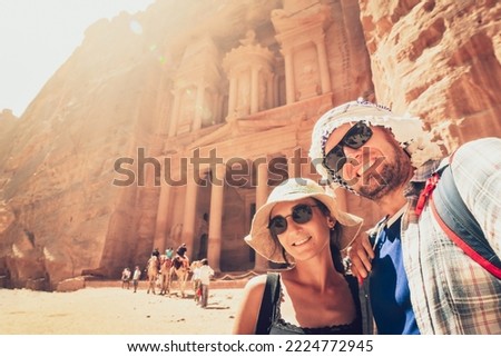 Young handsome couple excited taking selfie in Petra by Treasury landmark. Travelous man and woman, smiling and looking at camera. Travel, happiness and lifestyle concepts.