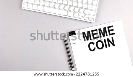 MEME COIN text on a paper with keyboard on grey background Royalty-Free Stock Photo #2224781255