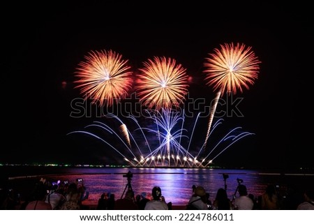PATTAYA CHONBURI,NOVEMBER Beautiful colorful fireworks night scene shot at Pattaya International Fireworks Festival and silhouette Group people shoot and record pictures firework show with smartphone