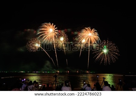 PATTAYA CHONBURI,NOVEMBER Beautiful colorful fireworks night scene shot at Pattaya International Fireworks Festival and silhouette Group people shoot and record pictures firework show with smartphone