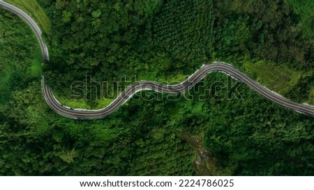 aerial top view beautyfull curve road on green forest in the rain season background, rural routes connecting cities in the north of thailand  Royalty-Free Stock Photo #2224786025