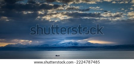 Idyllic view of seascape and silhouette mountain range against cloudscape during twilight