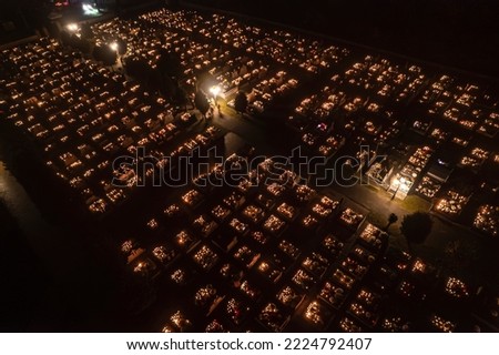 Unusual city scape. Numerous graves in cemetery decorated with numerous beautiful candles and lanterns Aerial drone perspective. Christian holy days. High quality photo
