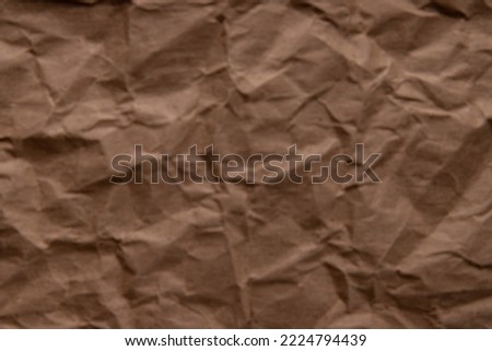 crumpled paper. sheet of brown cardboard paper. detailed high resolution defocused blurred texture. abstract background for wallpaper.