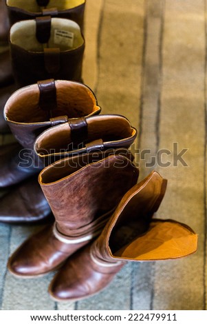 Cowboy boots of wedding party at fron tof fireplace.