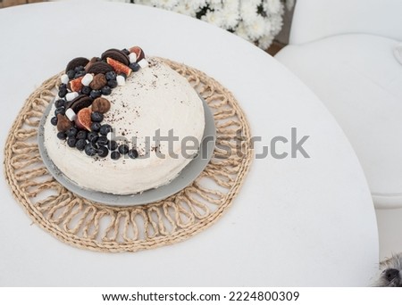 The dog wants to reach the cake. A beautiful cake is on the table and a dog's nose is in the corner of the picture
