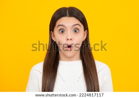Surprised emotions of young teenager girl. Close up portrait of caucasian teen girl. Head shot of cute teenager child on yellow isolated studio background.