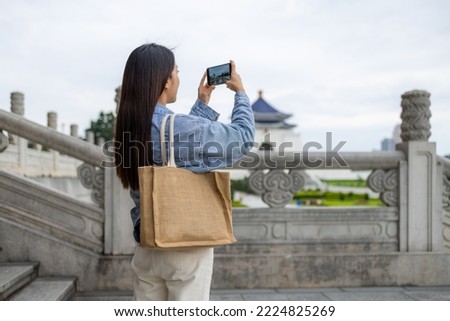 Tourist woman use mobile phone to take photo in Chiang Kai shek Memorial Hall in Taiwan