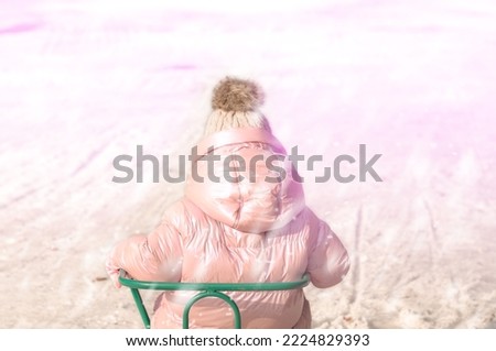 Joyful little girl plays in the snow, sledding, joy, happiness, holiday