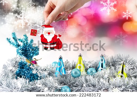 Christmas decoration of young woman hand holding santa claus