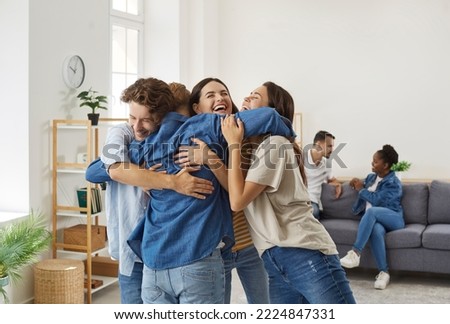 Happy friends who haven't seen each other for long time are hugging during meeting at home. Male and female best friends are laughing and hugging each other tightly. Friends reunion concept. Royalty-Free Stock Photo #2224847331