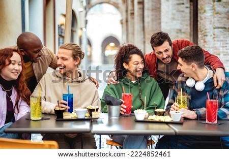 Multiracial trendy friends having fun moment at fancy cocktail bar - Beverage life style concept with people laughing together on happy hour out side at sidewalk restaurant garden - Bright filter Royalty-Free Stock Photo #2224852461