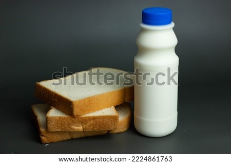 Milk in a jar with four slices of bread on a black background.