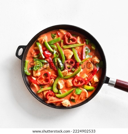 Thai style red chicken curry with vegetables in cooking pan over white stone background. Top view, flat lay, close up Royalty-Free Stock Photo #2224902533