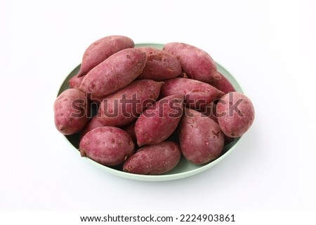 A heap of purple sweet potatoes placed on a plate isolated on white background