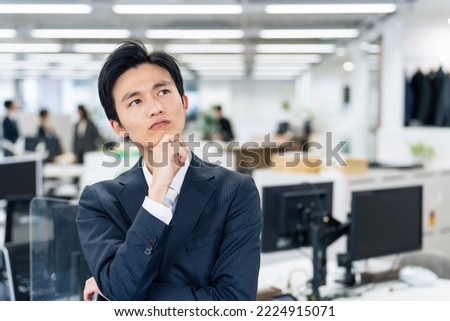 Young Asian businessman worrying in the office. Royalty-Free Stock Photo #2224915071