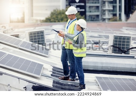 Sustainable engineering, solar panels and team doing maintenance on the rooftop of building in the city. Solar energy, ecology and industrial workers planning project with photovoltaic cells in town. Royalty-Free Stock Photo #2224924869