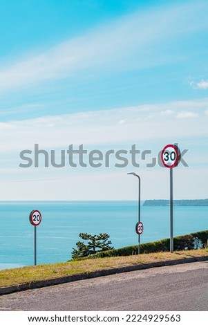 Road traffic speed signs on a road by the sea
