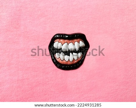 Scary Funny Jaw With Black Lips and Crooked Teeth on Pink Monochrome Textile Background