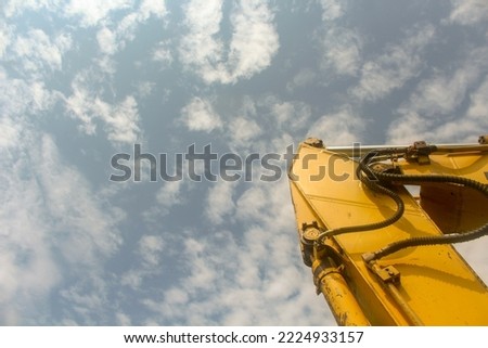 Photos of detailed parts of the Yellow Excavator from various sides angles, parked on a grass field in a village located at the foot of the thousand mountains, Songputri - Indonesia.