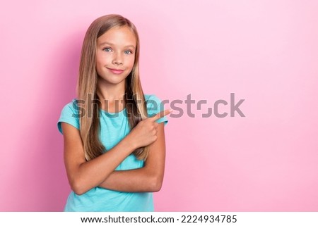 Closeup photo of cute little pretty preteen girl wear cyan t-shirt finger pointing empty space advertisement deal isolated on pastel pink color background