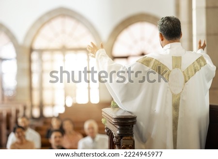 Pastor, church and man praying for his congregation to god for spiritual wellness on a Sunday. Hope, religious and priest preaching to christian people standing on a podium in a cathedral building. Royalty-Free Stock Photo #2224945977