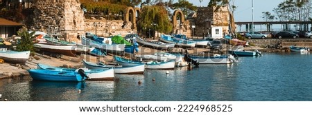 Motor boats parked in the port of Nessebar, Bulgaria. Beautiful panorama of the old city. Fishing boats and yachts on the pier in the bay. Beautiful postcard with a European picture. Banner
