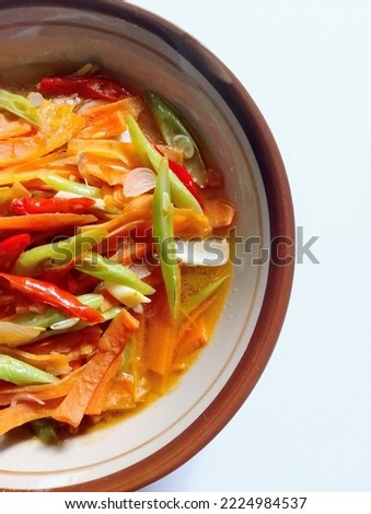 sauteed carrots and beans served in a bowl.  There is red chili added, stir-fried together to add flavor and enhance the appearance