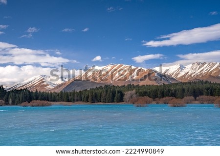 Beautiful mountainous view of the turquoise color Lake Tekapo as view from the State Highway 8. Photo taken during winter with snow capped mountain.