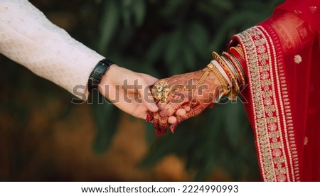 indian wedding candid photo of groom and bride holding hand Royalty-Free Stock Photo #2224990993