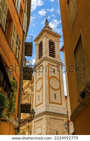 Bell tower of Sainte Reparate Cathedral Basilique on Place Rossetti seen in an opening between traditional buildings in Nice, French Riviera, France Royalty-Free Stock Photo #2224992779