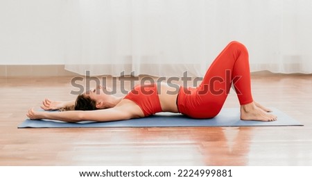 Middle aged well looking woman fitness instructor in red Sportsw