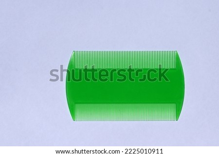 Green plastic head lice and nit comb