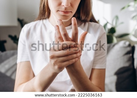 Cropped shot unhealthy female massage hand with wrist pain, rheumatoid arthritis. Young woman suffer from numbing pain in hand, numbness fingertip, arthritis inflammation, peripheral neuropathies Royalty-Free Stock Photo #2225036163