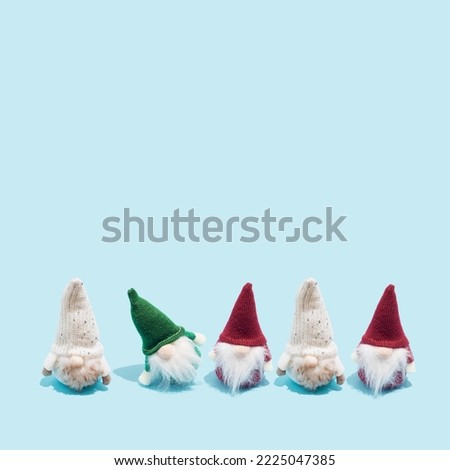 Minimal winter holidays composition with cute Christmas scandinavian gnomes on bright blue background with copy space.