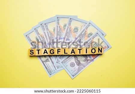 A picture of stagflation word on wooden blocks with fake money.