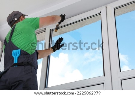 Worker installing double glazing window indoors, low angle view Royalty-Free Stock Photo #2225062979