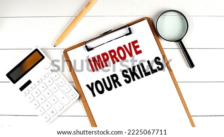 IMPROVE YOUR SKILLS words on a clipboard, with calculator, magnifier and pencil on the white wooden background