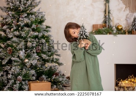 Cute, beautiful child girl at Christmas on the background of a decorated Christmas tree.